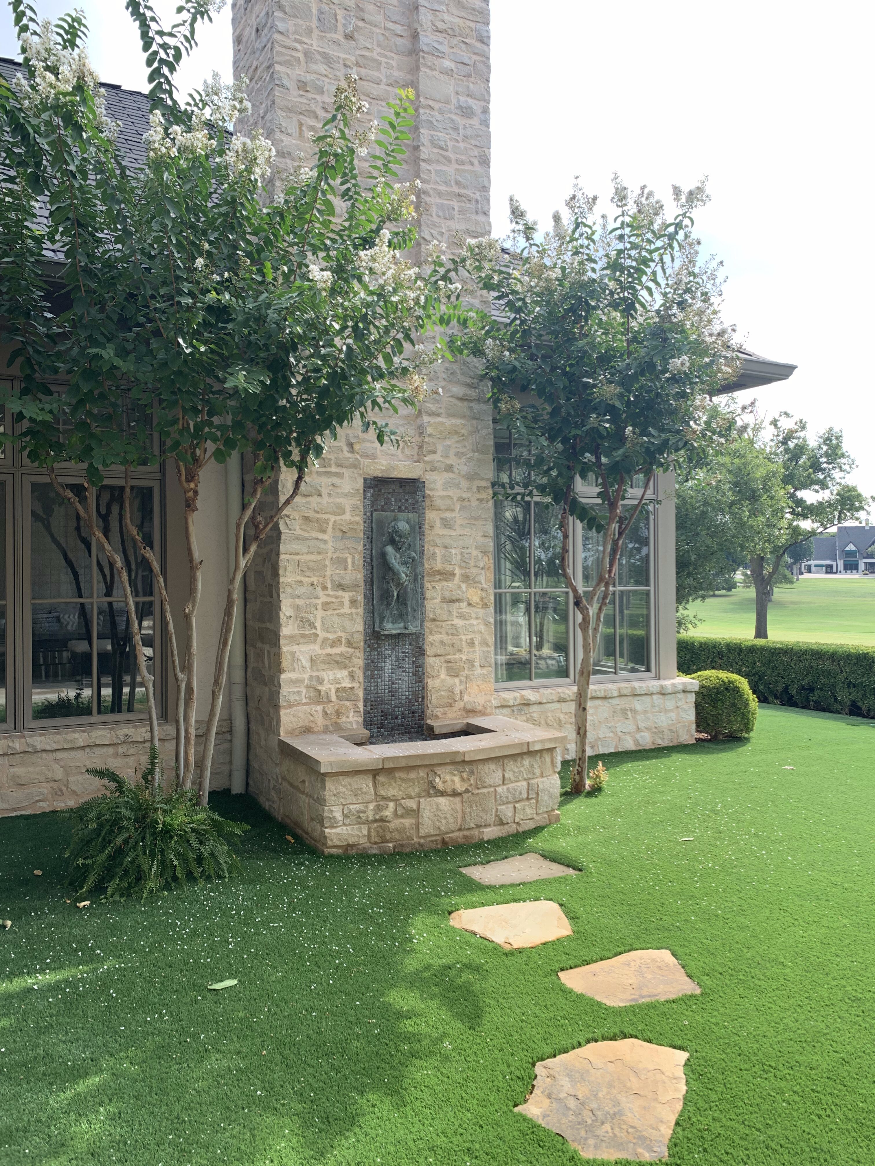 Landscaping fountain, flagstone pavers and shrubs