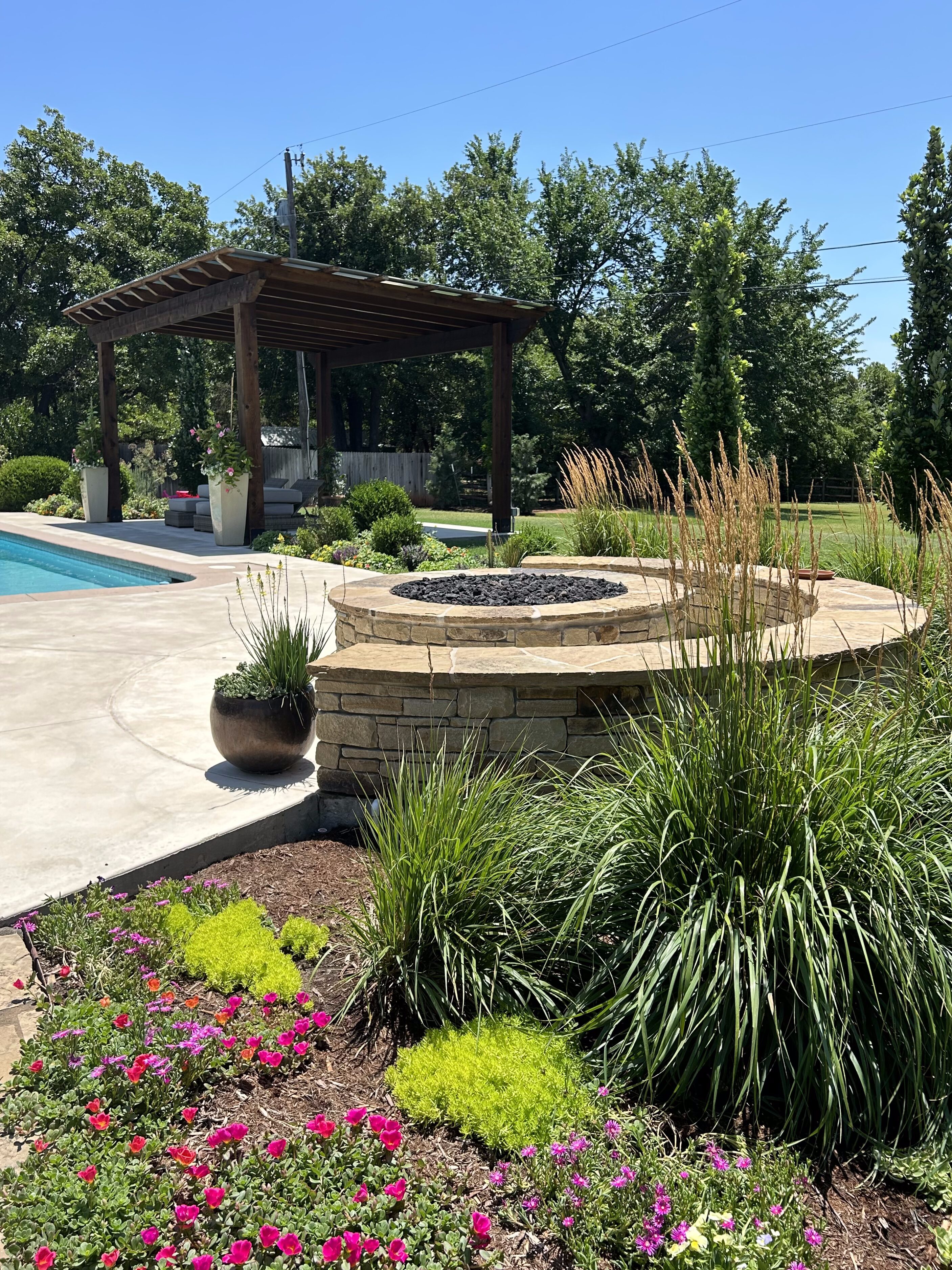 Backyard with pergola and firepit with landscape design