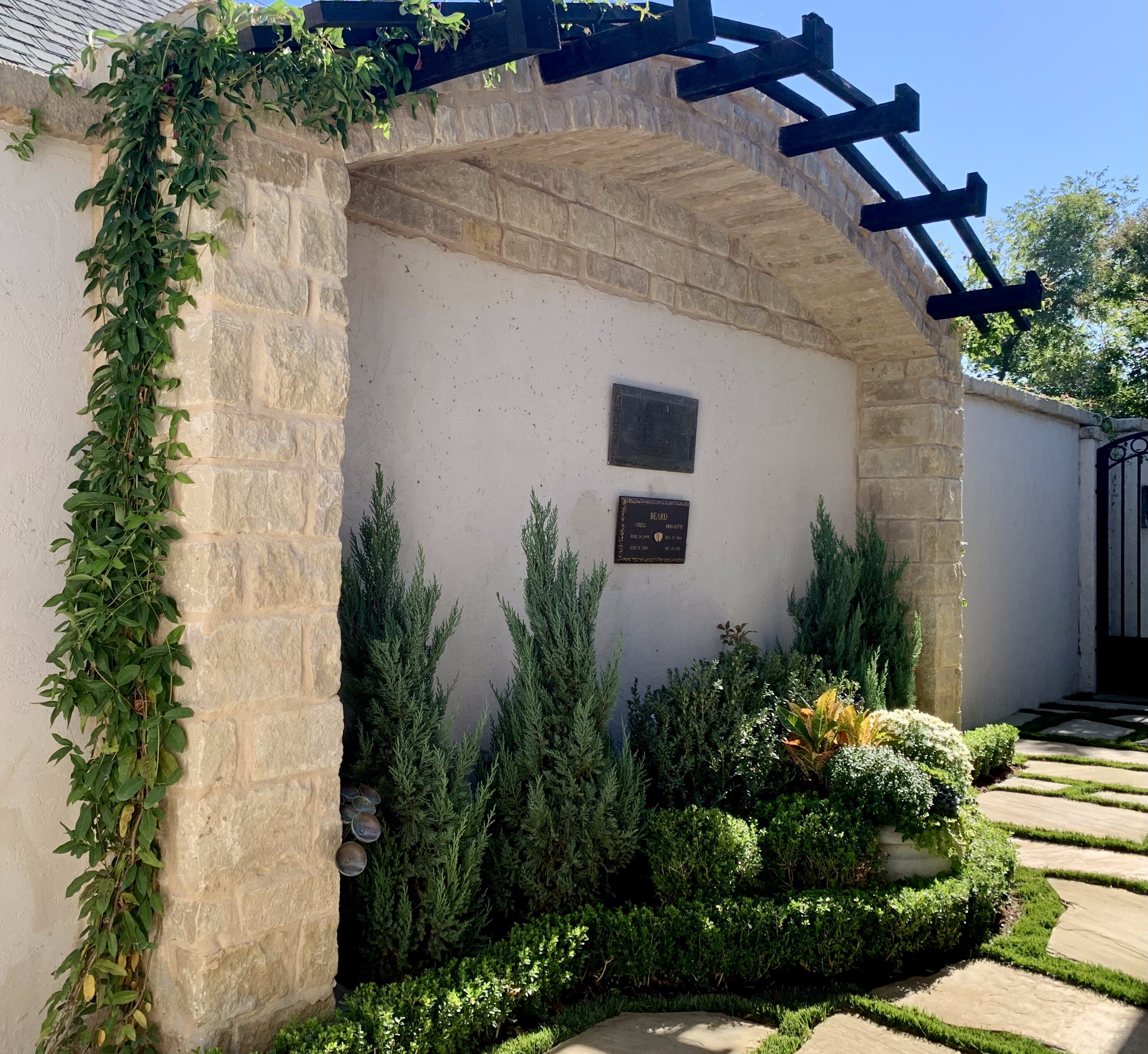 Arched trellis with landscaping plants and flagstone pavers